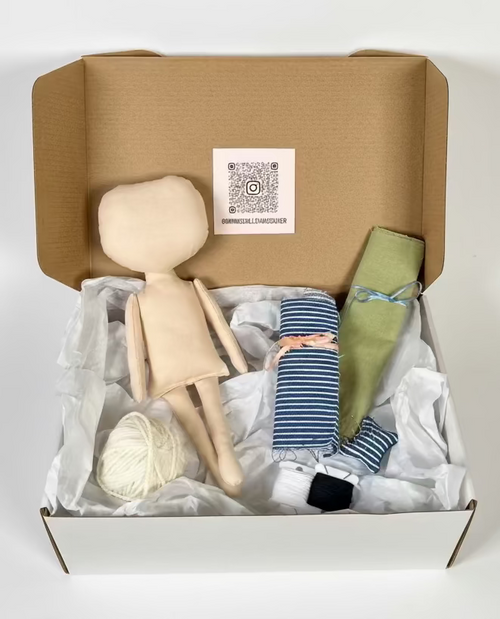 Box containing a cloth doll, fabric, thread, and yarn. 